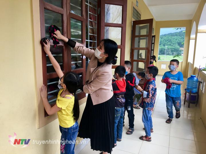 Cô giáo, học sinh trường Tiểu học xã Hòa Sơn- Đô Lương lau chùi, vệ sinh phòng học sạch sẽ.