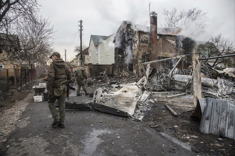 Binh sĩ Ukraine bên những mảnh vỡ của một chiếc máy bay bị bắn rơi ở Kiev, Ukraine ngày 25-2. Ảnh: AP