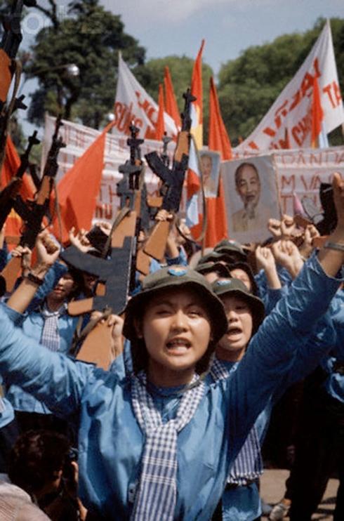 Lực lượng giải phóng tiến vào Sài Gòn mang theo cờ và ảnh chân dung Chủ tịch Hồ Chí Minh ngày 30/4/1975. Ảnh: Phóng viên quốc tế Jacques Pavlovsky/Sygma/CORBIS.