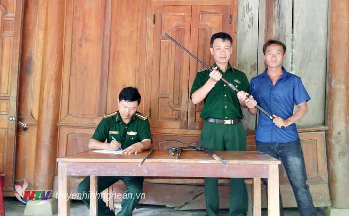  Cán bộ đồn Biên phòng cửa khẩu quốc tế Nậm Cắn tiếp nhận súng do người dân giao nộp.