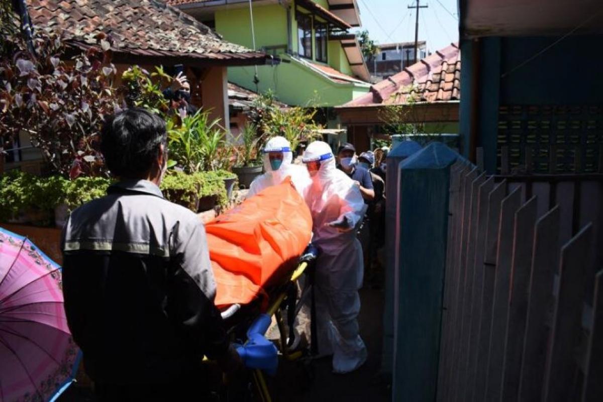 Các nhân viên y tế di chuyển thi thể nạn nhân mắc Covid-19 tử vong khi cách ly tại nhà ở Bandung, ngày 28/7/2021. Ảnh: AFP