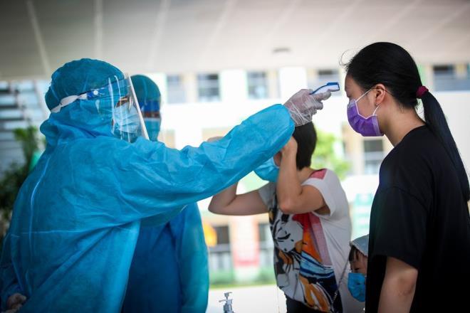 Nhân viên y tế kiểm tra thân nhiệt cho người dân ở Hà Nội.