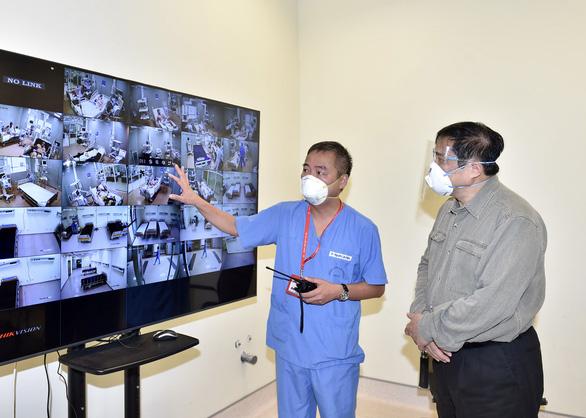 Bác sĩ Nguyễn Lân Hiếu, Giám đốc Bệnh viện Đại học Y Hà Nội phụ trách Bệnh viện dã chiến điều trị COVID-19 tại Bệnh viện quốc tế Becamex giới thiệu với Thủ tướng hoạt động điều trị chung của Bệnh viện dã chiến.