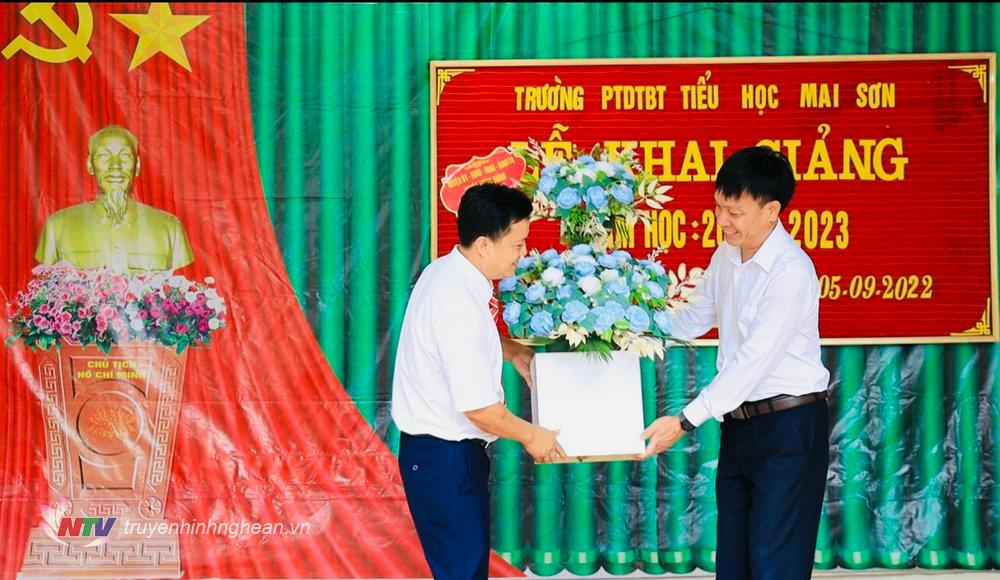 Ông Kha Văn Ót, Phó Chủ tịch HĐND huyện Tương Dương trao quà và lẵng hoa tươi thắm chúc mừng thầy và trò nhà trường.