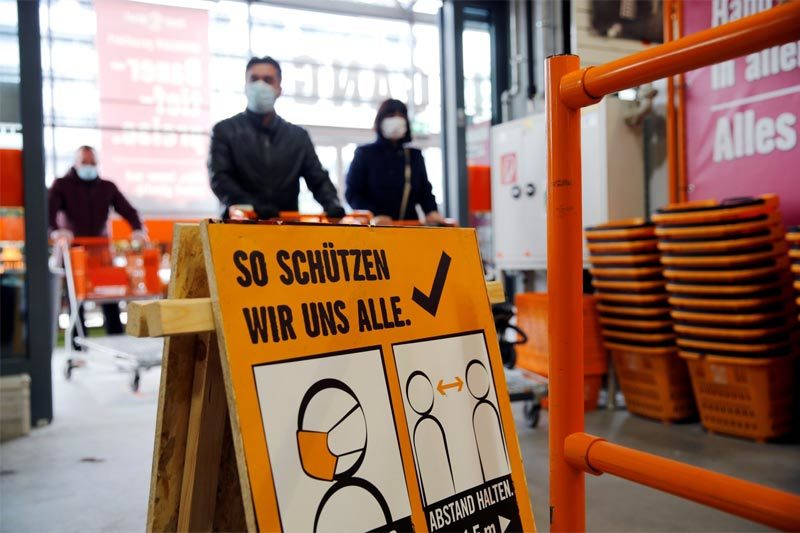 Người dân đeo khẩu trang khi vào siêu thị mua sắm ở Vienna, Áo. Ảnh: Reuters