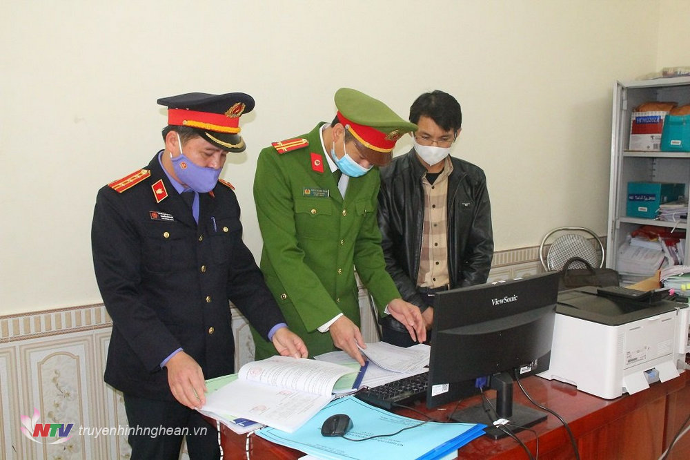 Cơ quan chức năng tiến hành khám xét nơi làm việc bị can Hoàng Minh Hùng (áo đen ngoài cùng bên phải)