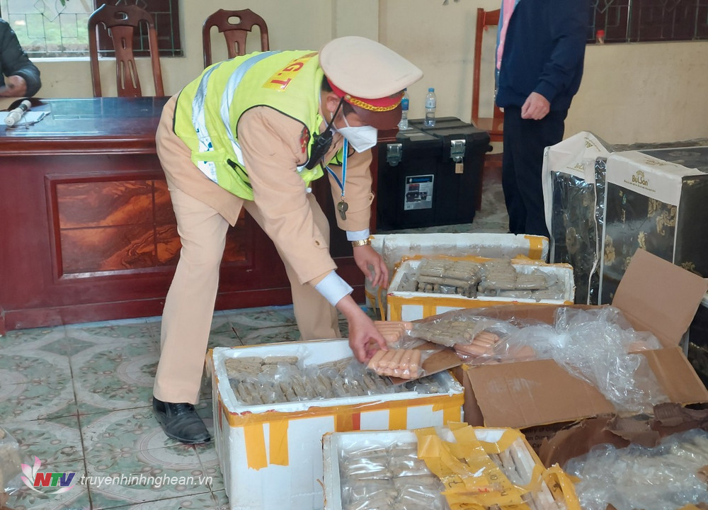 Cán bộ Trạm Cảnh sát Giao thông Diễn Châu kiểm đếm lô hàng xúc xích, giò chả đã bốc mùi hôi thối phát hiện trên xe khách 37B-02835.