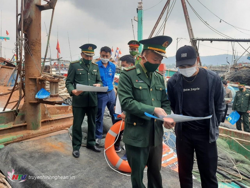 Cán bộ chiến sỹ Đồn Biên Phòng Quỳnh Phương phát tờ rơi tuyên truyền chống khai thác bất hợp pháp cho các ngư dân