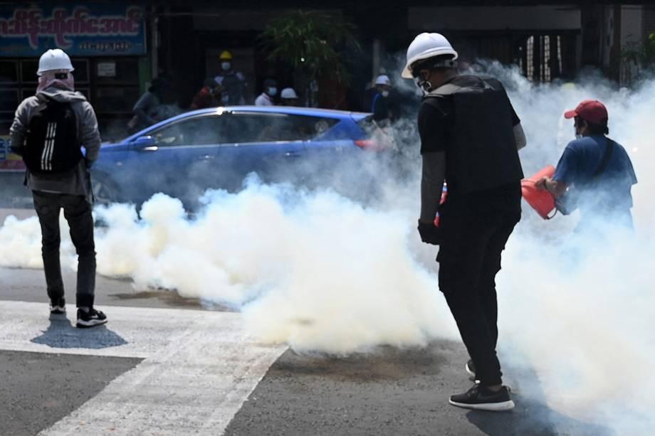Người biểu tình tìm cách dập khói từ lựu đạn hơi cay tại Yangon.