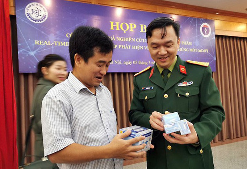 Thượng tá Hồ Anh Sơn, chủ nhiệm đề tài (phải), cùng bị can Phan Quốc Việt (chủ tịch kiêm tổng giám đốc Công ty Việt Á) giới thiệu bộ kit test COVID-19. Ảnh: VGP