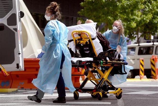 Nhân viên y tế chuyển bệnh nhân COVID-19 tới bệnh viện tại Melbourne, Australia. 
