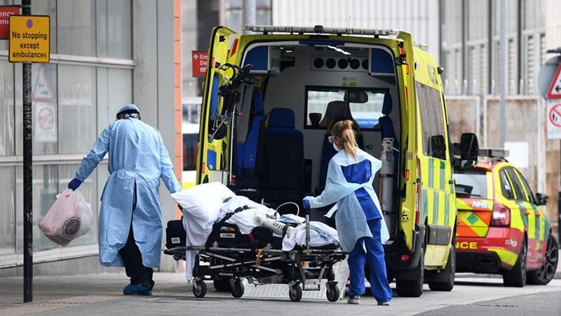 Nhân viên y tế chuẩn bị đưa bệnh nhân Covid-19 vào bệnh viện ở London. Ảnh: AFP