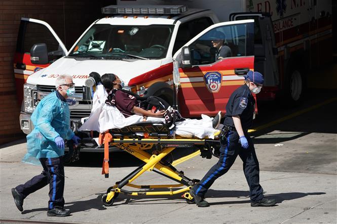 Nhân viên y tế chuyển bệnh nhân mắc COVID-19 từ xe cứu thương vào một bệnh viện ở New York, Mỹ ngày 6/4/2020. 