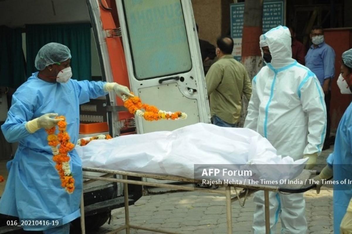 Các nhân viên y tế khiêng xác một bệnh nhân Covid-19 từ xe cấp cứu tại Nigambodh Ghat ở Delhi, Ấn Độ. Ảnh: AFP