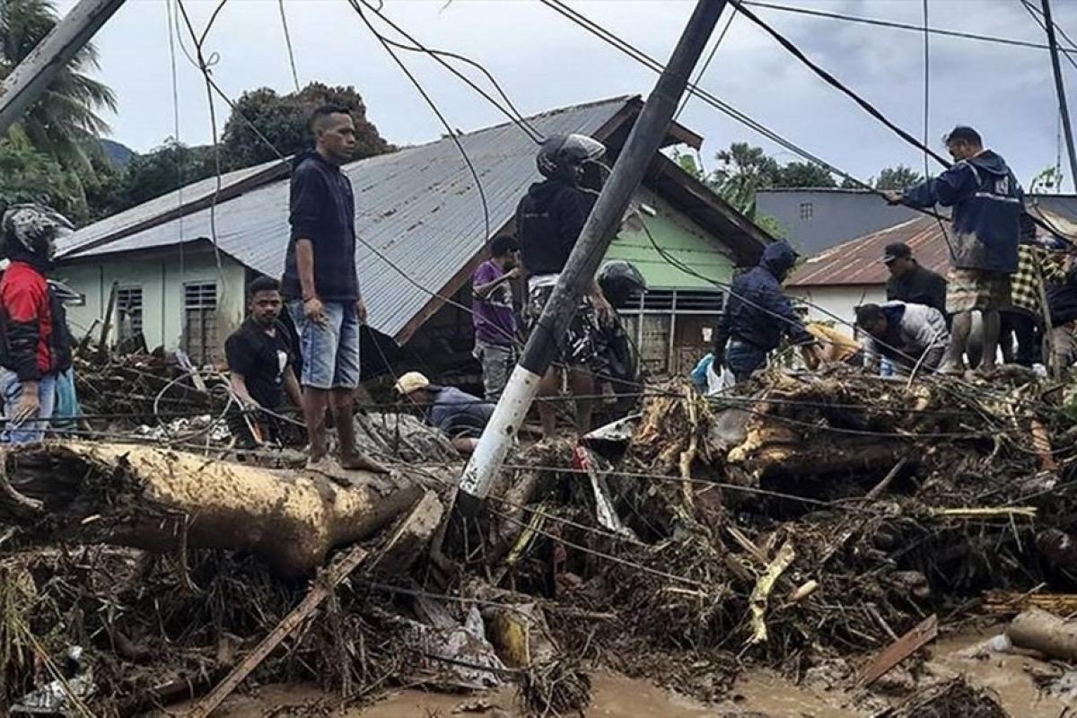 Người dân làng Waiwerang, phía đông đảo Flores, Indonesia trước hậu quả tàn phá nặng nề của mưa bão. Ảnh: AFP