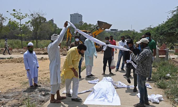Người thân, bạn bè và nhân viên nghĩa trang chuẩn chôn cất thi thể nạn nhân Covid-19 tại một nghĩa địa ở New Delhi, Ấn Độ hôm 28/1. Ảnh: AFP.