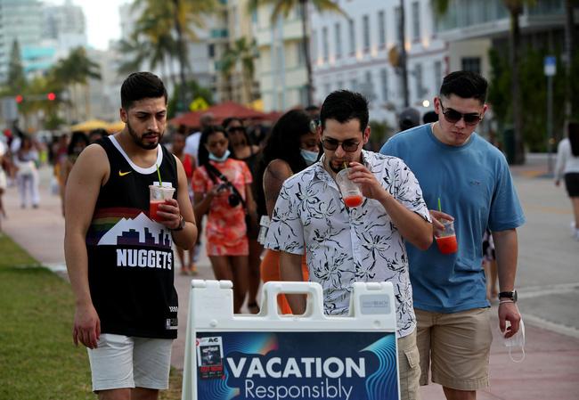 Nhóm du khách đọc hướng dẫn an toàn phòng chống dịch bệnh COVID-19 ở khu trung tâm tại TP.Miami (bang Florida, Mỹ). Ảnh: Reuters