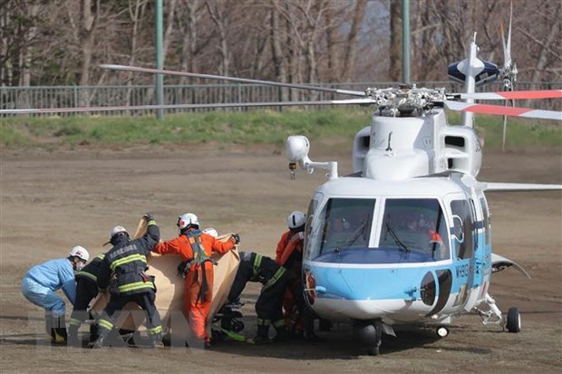 Lực lượng cứu hộ chuyển nạn nhân trong vụ chìm tàu du lịch từ trực thăng cứu hộ tới xe cứu thương tại đảo Hokkaido, Nhật Bản ngày 24/4. 