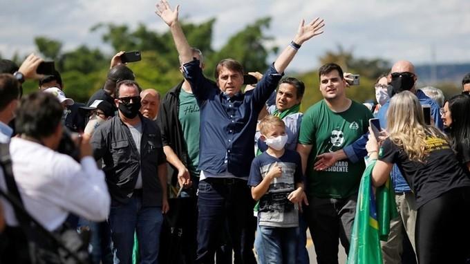 Tổng thống Brazil Jair Bolsonaro xuất hiện cùng đám đông ủng hộ bên ngoài cung điện Planalto ở thủ đô Brasilia hôm 24/5. Ảnh: Reuters