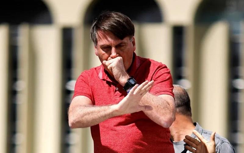 Tổng thống Brazil Bolsonaro ho khi phản đối cách ly xã hội phòng Covid-19. Ảnh: AFP.