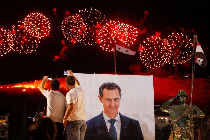 Người Syria ăn mừng chiến thắng vang đội của ông Assad. Ảnh: Reuters