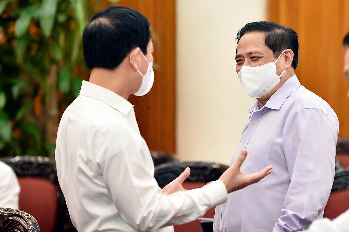 Thủ tướng Phạm Minh Chính và Bộ trưởng Nguyễn Mạnh Hùng trao đổi tại cuộc làm việc. 