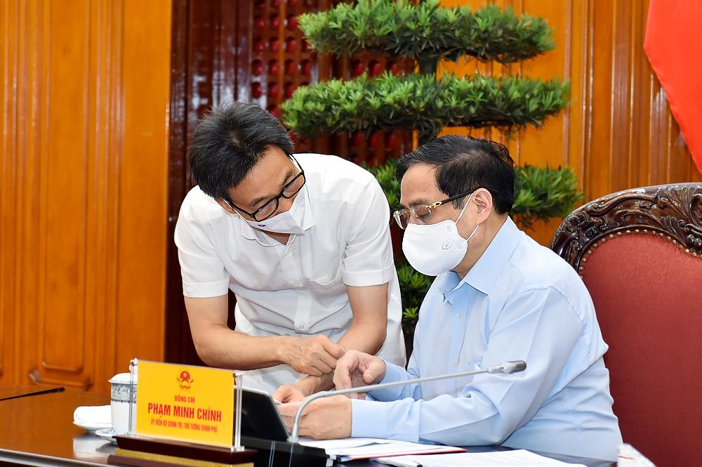Thủ tướng Phạm Minh Chính và Phó Thủ tướng Vũ Đức Đam trao đổi tại cuộc làm việc.