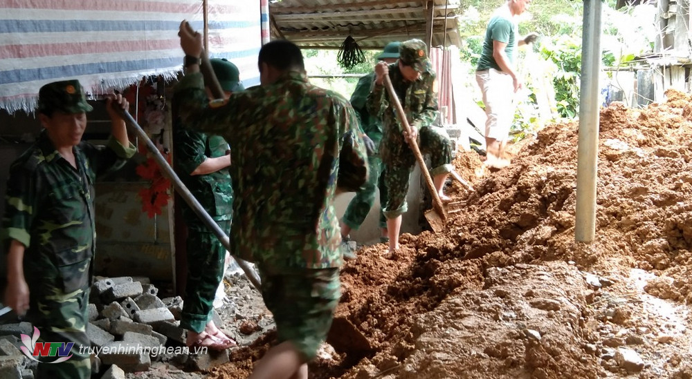 Cán bộ chiến sỹ Đồn BP Thông Thụ hỗ trợ người dân khắc phục hậu quả mưa lũ.