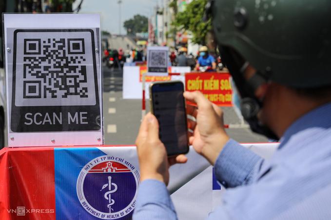 Người dân quét mã QR Code khai báo y tế điện tử khi đi qua chốt kiểm soát dịch bệnh tại quận Gò Vấp, TP HCM, tháng 6/2021. 