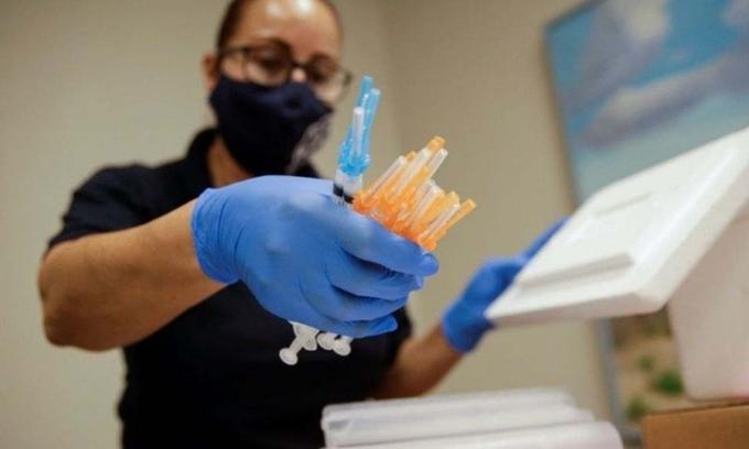 Một nhân viên y tế cầm các liều vaccine Covid-19 của Moderna và Pfizer tại trung tâm tiêm chủng ở El Paso, Texas, Mỹ, hôm 6/5. Ảnh: Reuters.