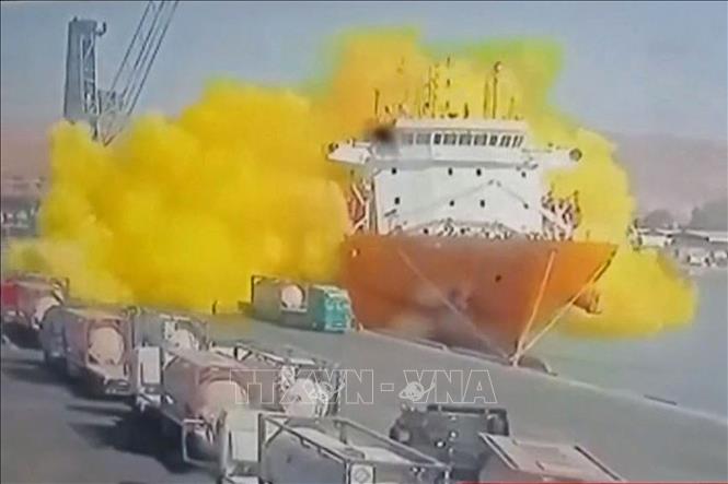 Đám khí màu vàng bùng lên sau khi một bồn chứa ga lớn rơi từ cần cẩu xuống con tàu đang neo đậu tại cảng Aqaba, Jordan ngày 27/6/2022 (ảnh phát trên kênh truyền hình Al-Mamlaka TV của Jordan). Ảnh: AFP/TTXVN