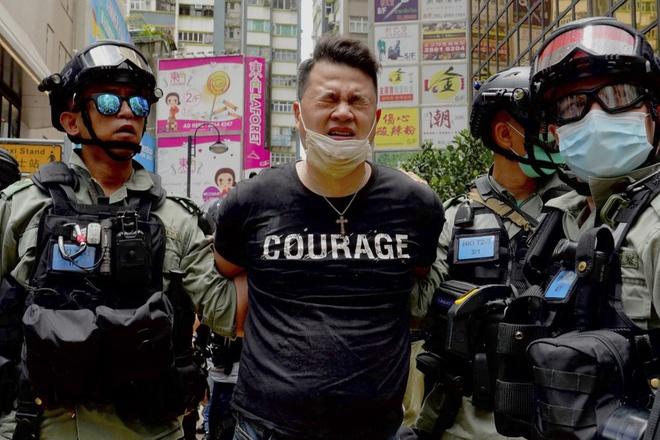 Cảnh sát bắt giữ một người biểu tình sau khi xịt hơi cay vào họ trong cuộc biểu tình ở vịnh Causeway hôm 1/7 ở Hong Kong. Ảnh: AP.