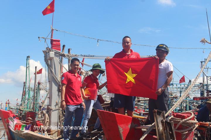 Đoàn thiện nguyện trao tặng cờ Tổ quốc cho các ngư dân.