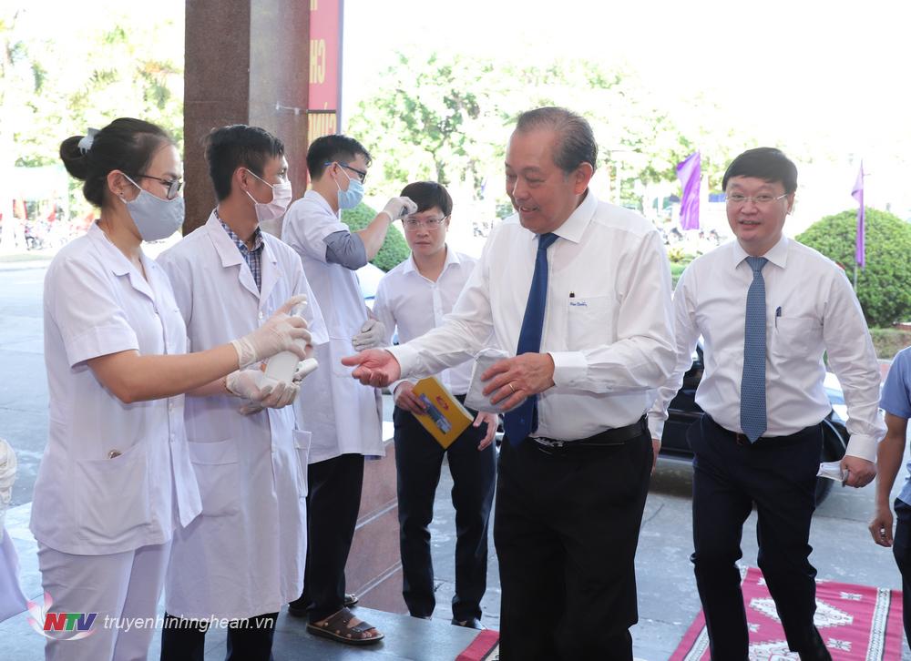 Phó Thủ tướng Thường trực Chính phủ Trương Hoà Bình thực hiện đo nhiệt độ, sát khuẩn tay trước khi tham dự lễ mít tinh.