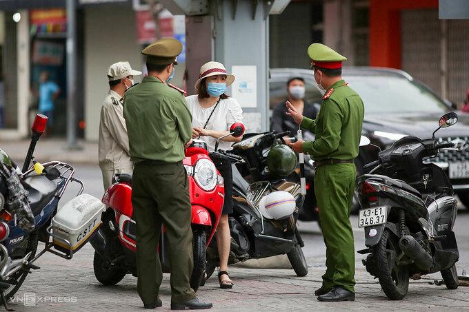 Công an kiểm tra người ra đường tại ngã tư Hoàng Hoa Thám - Lê Duẩn, người ra đường không thực sự cần thiết sẽ bị xử phạt. Ảnh: Nguyễn Đông.