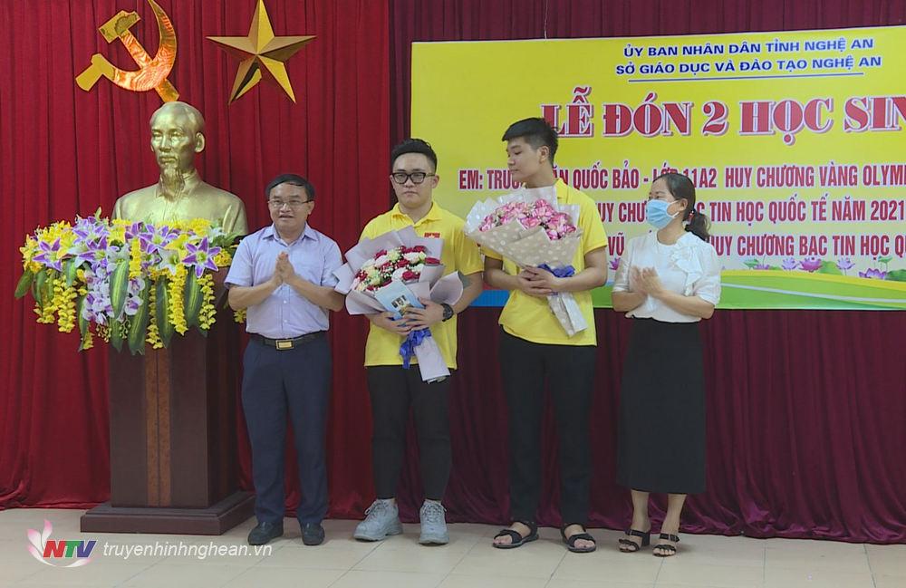 Trưởng ban Dân vận Tỉnh uỷ Ngọc Kim Nam tặng hoa chúc mừng 2 học sinh.