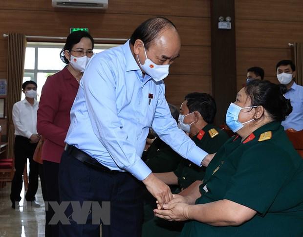 Chủ tịch nước Nguyễn Xuân Phúc thăm hỏi thương bệnh binh tại Trung tâm nuôi dưỡng bệnh binh nặng và Điều dưỡng người có công tỉnh Hà Nam, ngày 23/7/2021. Ảnh: TTXVN