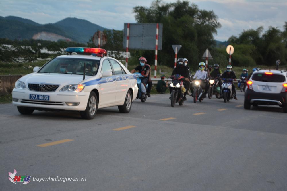 Lực lượng chức năng hỗ trợ đoàn xe di chuyển trên Quốc lộ đảm bảo an toàn giao thông.