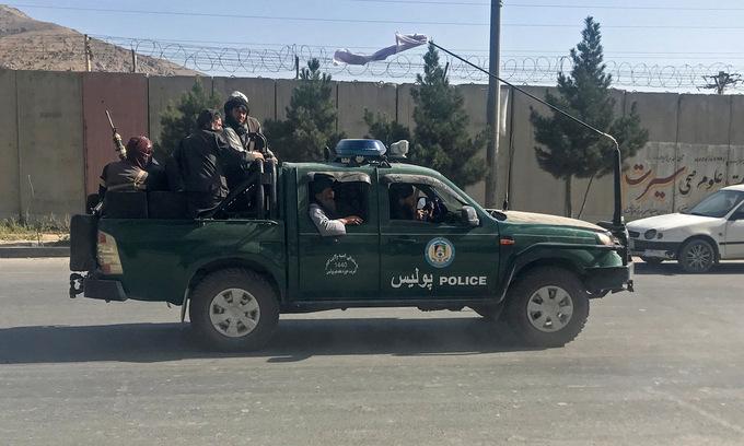Các tay súng Taliban trên xe cảnh sát tuần tra Kabul sáng 16/8. Ảnh: Reuters.