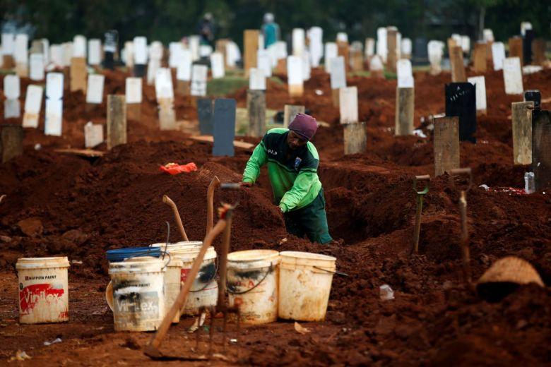 Công nhân đào huyệt cho các nạn nhân COVID tại nghĩa trang Pondok Ranggon ở Jakarta. Ảnh: Reuters