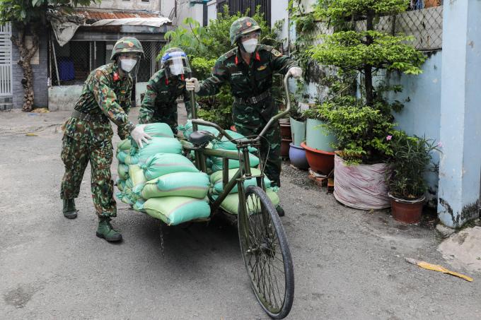 Bộ đội dùng xe đạp thồ tiếp tế thực phẩm cho người dân phường 2, quận Bình Thạnh, ngày 2/9. 