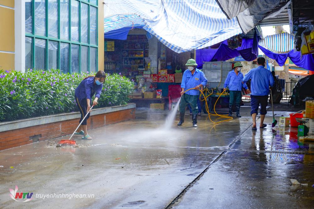 Ban quản lý trợ cùng các tiểu thương vệ sinh chợ sau mưa ngập.