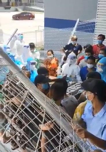 Nhiều người nôn nóng xô đổ cả hàng rào, chặn đường nhân viên và chen lấn giành giật đồ ăn tại khu điều trị dã chiến - Ảnh cắt từ video