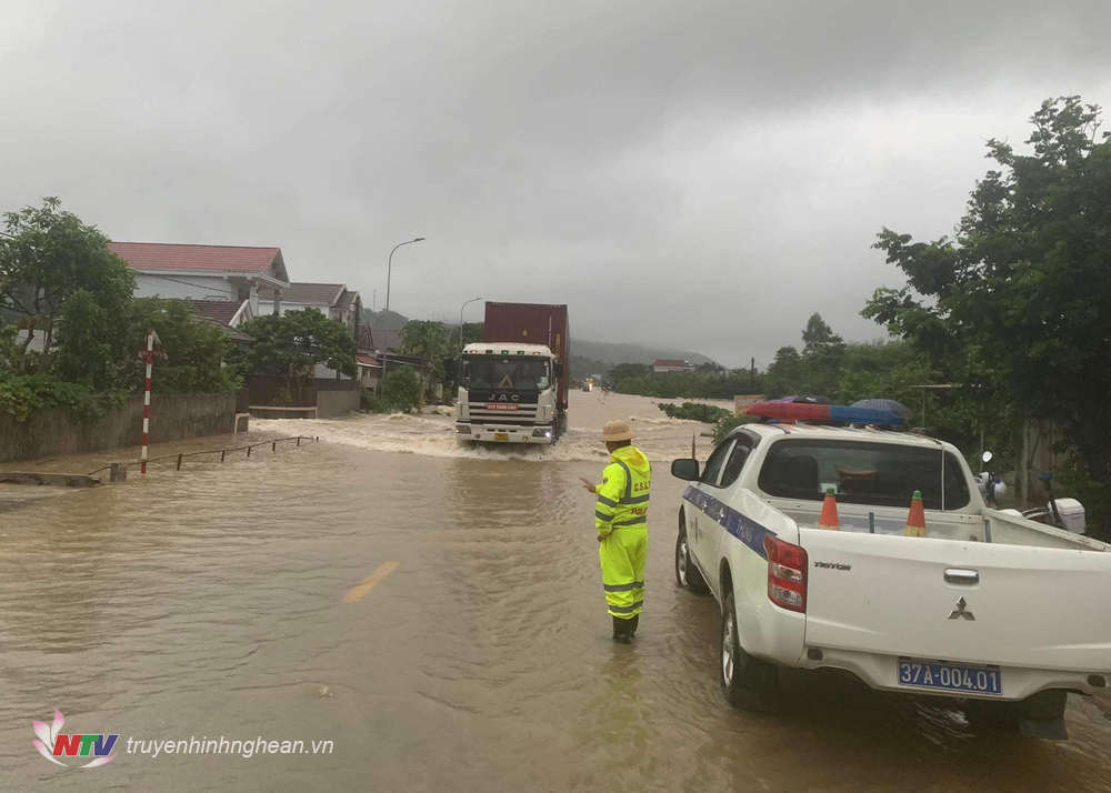 Lực lượng Cảnh sát giao thông hướng dẫn các phương tiện lưu thông qua đoạn bị ngập nước.