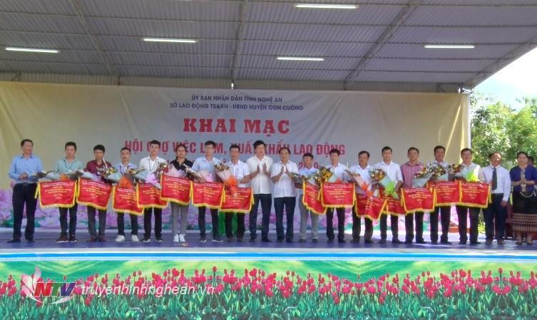 Lãnh đạo Sở LĐ-TB&XH và lãnh đạo huyện Con Cuông tặng hoa cho các đơn vị, doanh nghiệp tham gia Hội chợ.