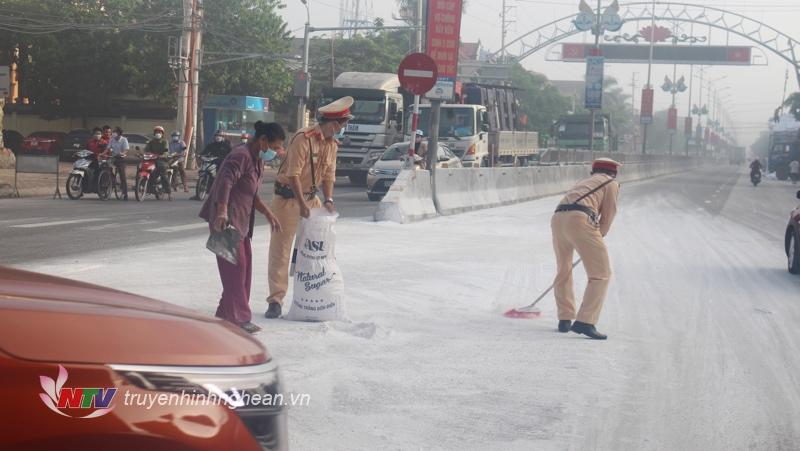 Cảnh sát giao thông giúp lái xe thu gom bột sắn bị rơi trên đường