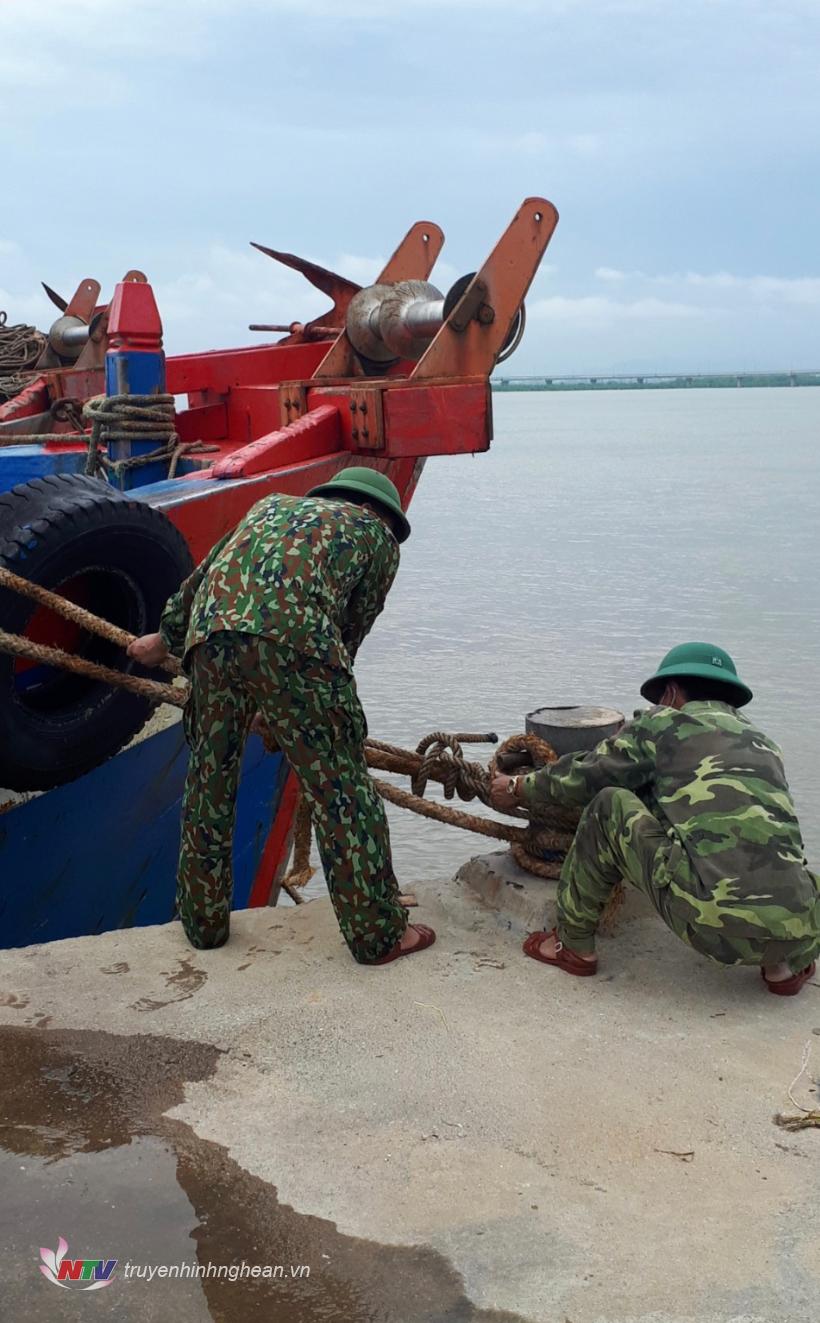 Cán bộ đồn Biên phòng cửa khẩu cảng Cửa Lò - Bến Thủy giúp người dân chằng néo tàu thuyền.