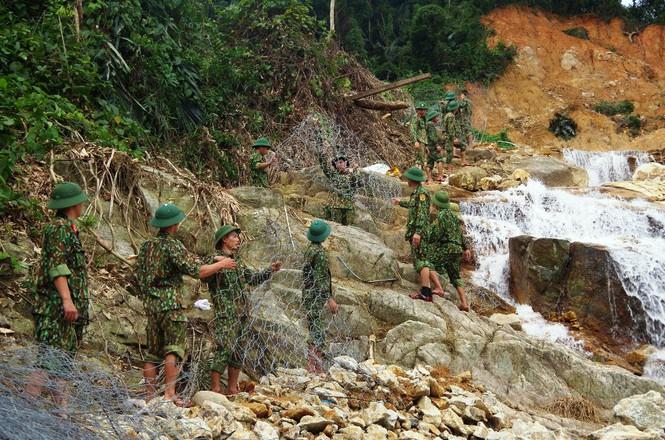 Bộ đội chuyển rọ sắt xuống lòng suối Rào Trăng để chuẩn bị xếp đá đắp đập tạm.