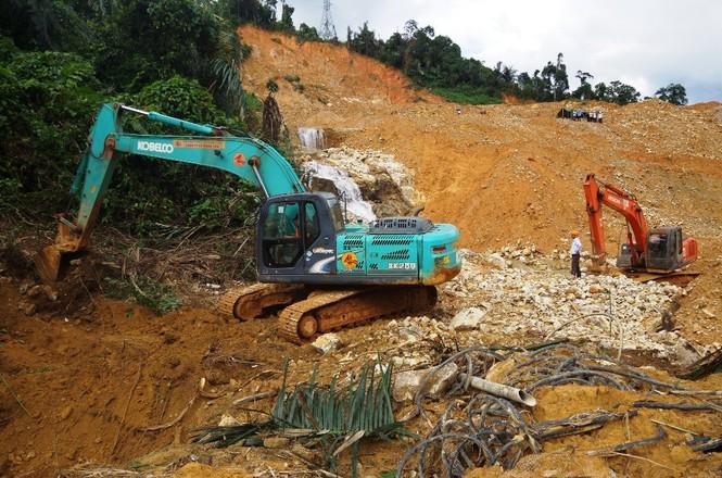 Phương tiện cơ giới đào đất ven suối Rào Trăng để chỉnh chuyển dòng chảy.