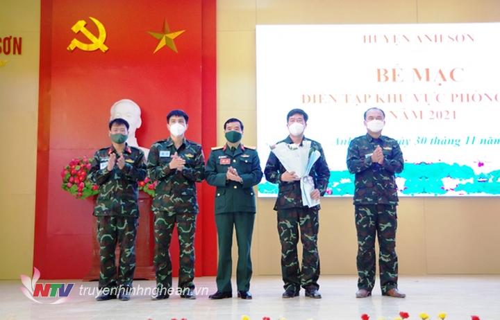 đại tá Phạm Văn Đông, PBT đảng ủy, Chính ủy bộ chỉ huy quân sự tỉnh tặng hoa chúc mừng Ban Chỉ đạo diễn tập phòng thủ huyện Quế Phong. 